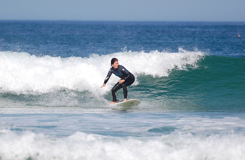 Learn to surf , a surfing student rides a wave in a surf lesson in Manhattan Beach, Los Angeles County